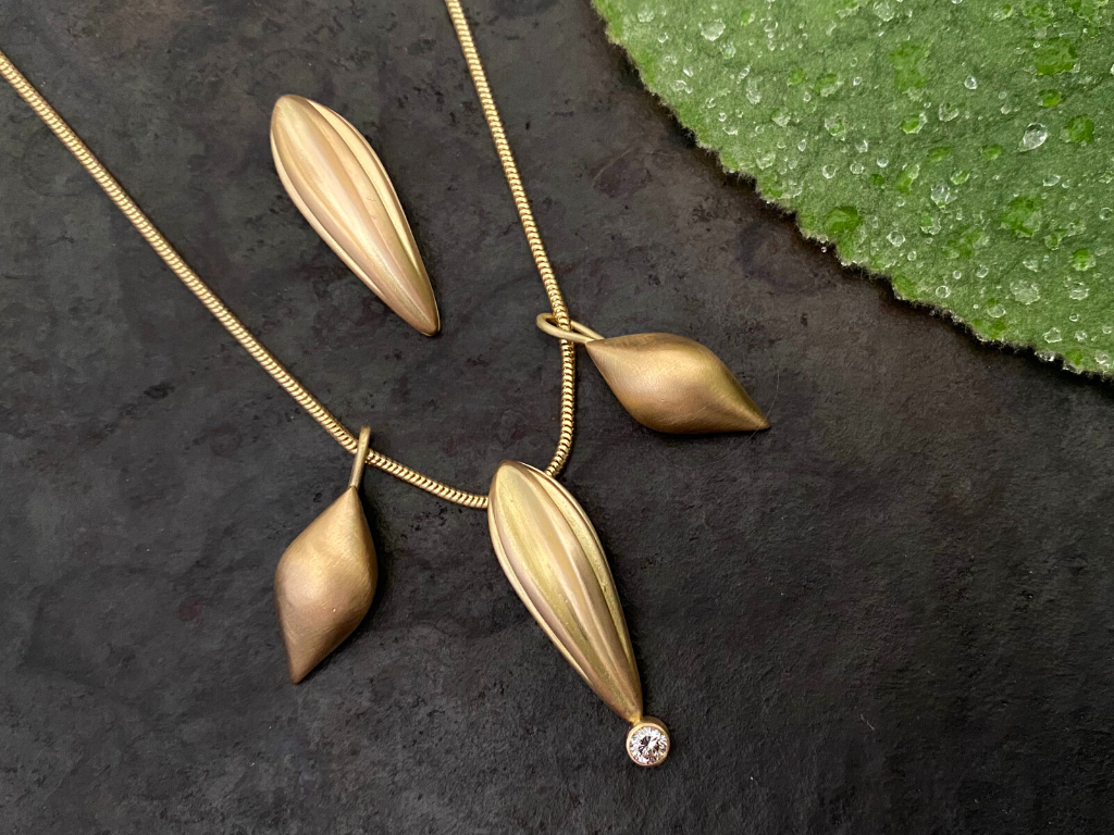 The Akasha Pendant with diamond accendted with wisdom charms.