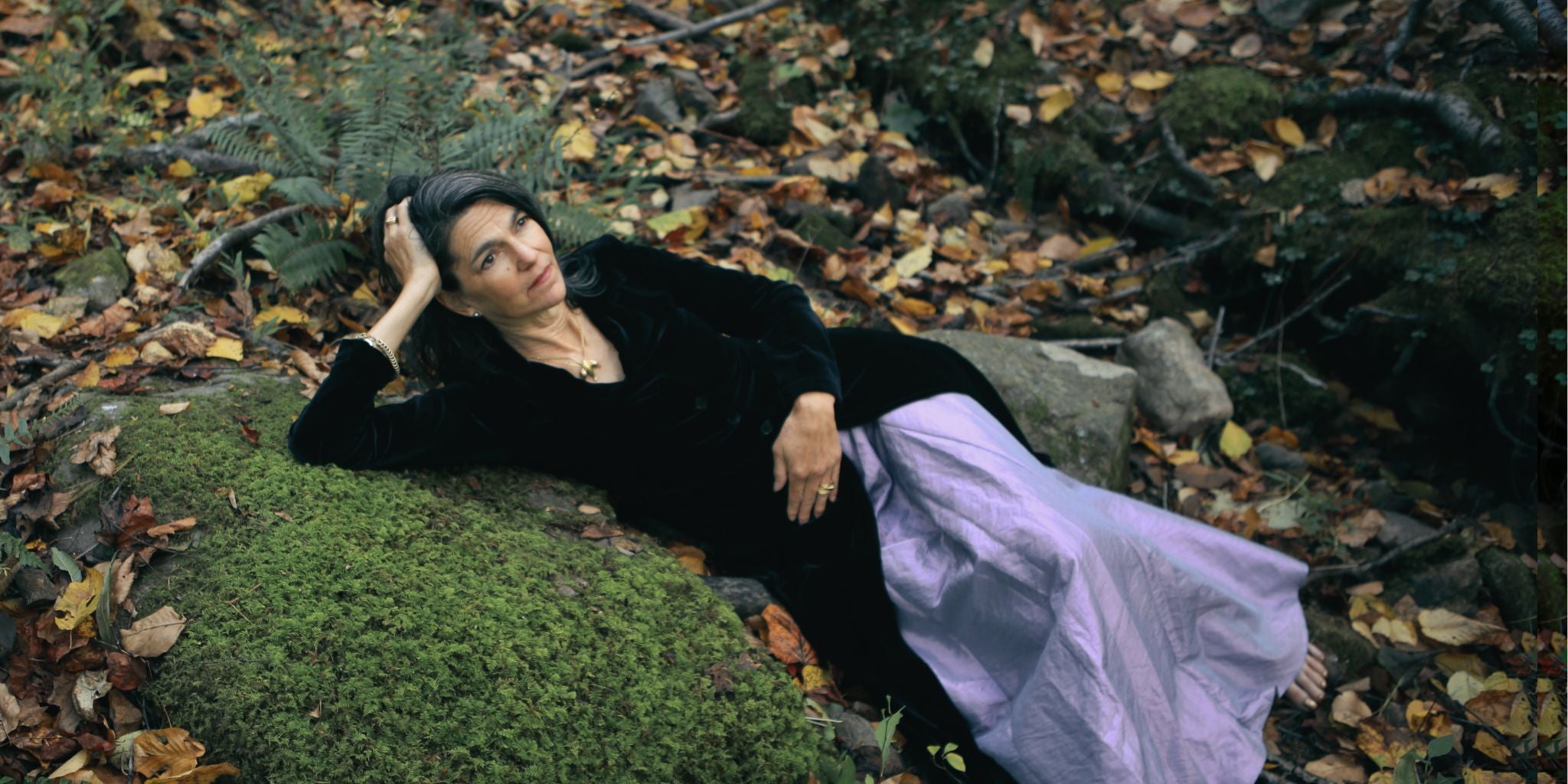 Sarah laying in the creek in a gorgeous dress.