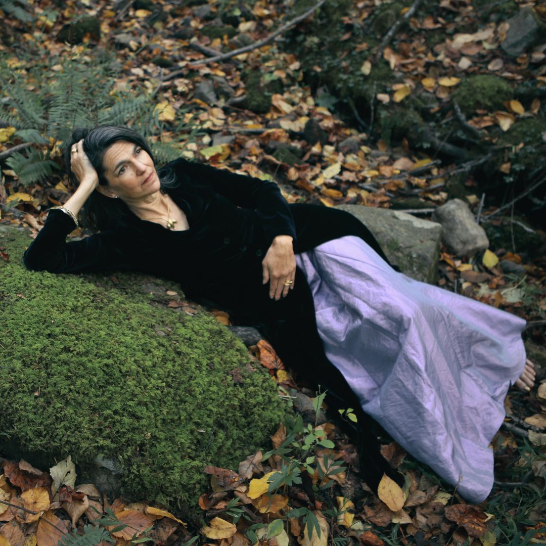 Sarah laying in the creek in a gorgeous dress.