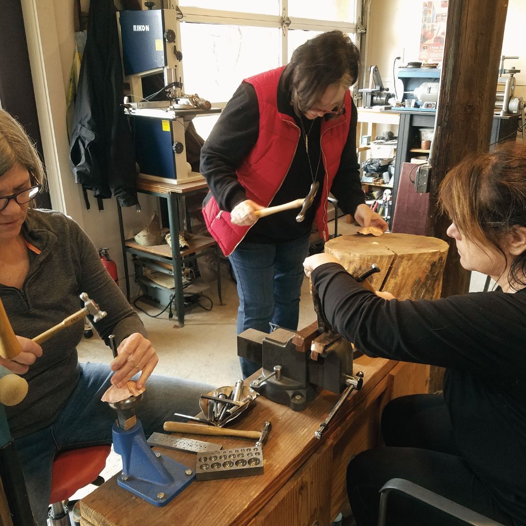 In studio action shot of a metalsmithing class.