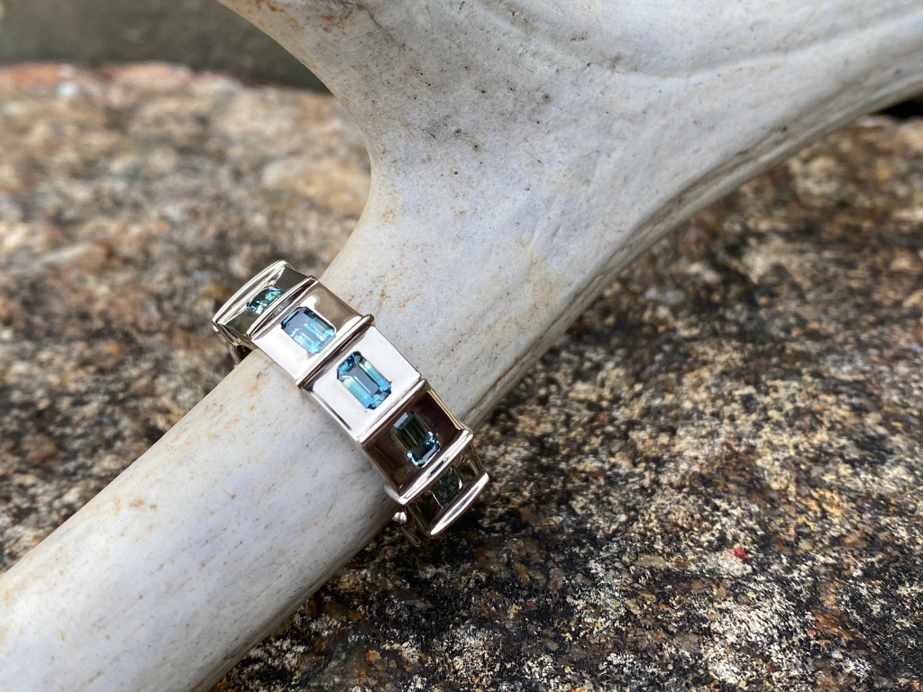 Silo Windows Ring- Men's- This mighty ring was designed to complement the Silo Ring with a masculine edge. It features six parti-sapphires symbolizing the silo's windows and the river’s hues. The crisp standing seams in between the diamonds mimic those of the Silo ring with a little more heft and crisp lines.